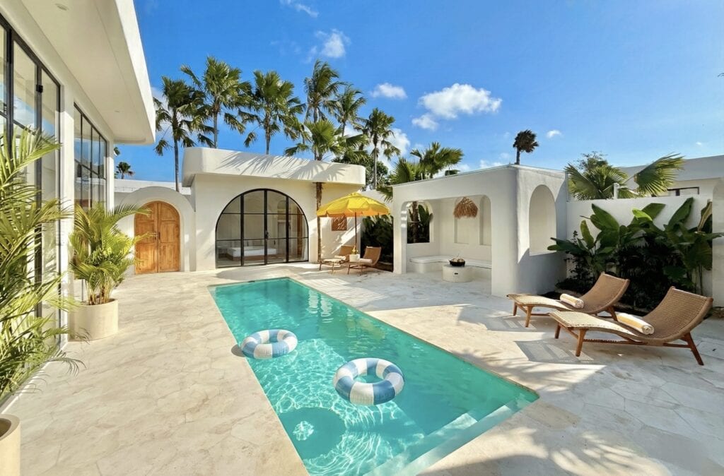 High-end tropical-modern villa featuring a private pool, sun loungers, and lush greenery in Uluwatu. Perfect for a luxurious getaway.