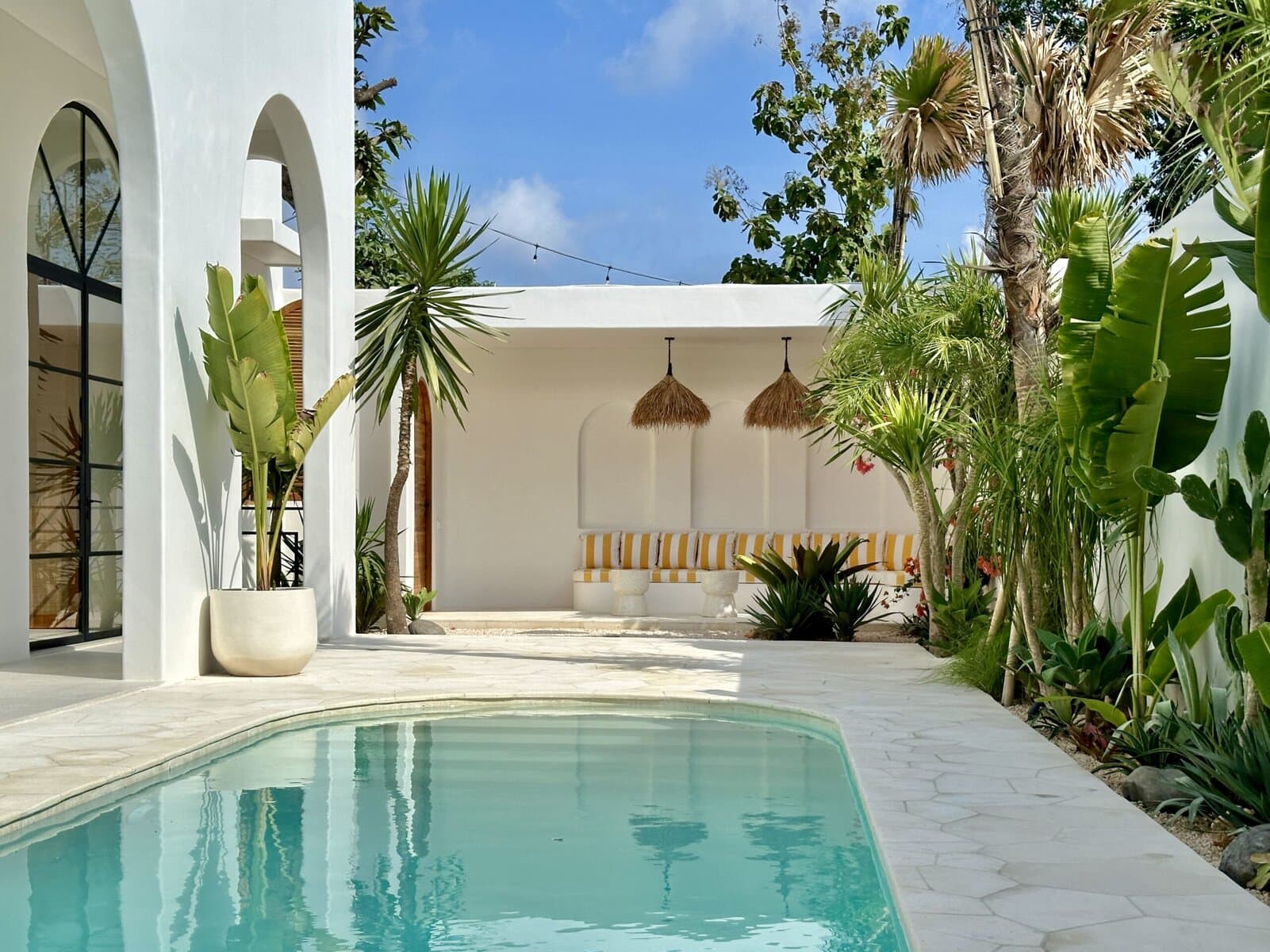 Modern two-bedroom Uluwatu villa with pool, lush greenery, and minimalist Balinese design.