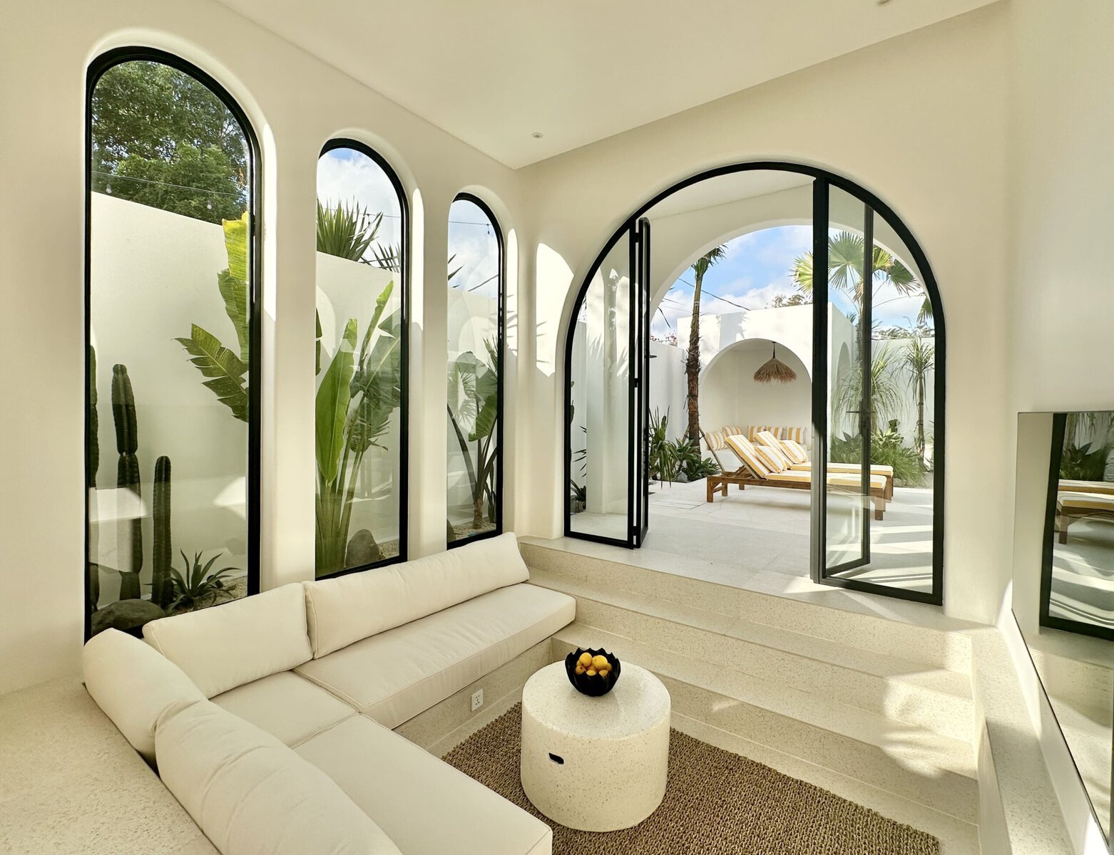 Bright, modern interior with indoor-outdoor flow, surrounded by lush greenery.