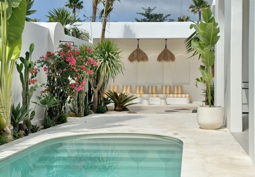 Stunning modern villa in Uluwatu featuring a pool, lush greenery, and stylish design.