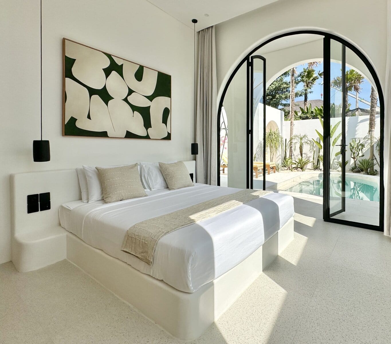 Stylish bedroom with pool view and outdoor garden, blending modern comfort with tropical serenity.