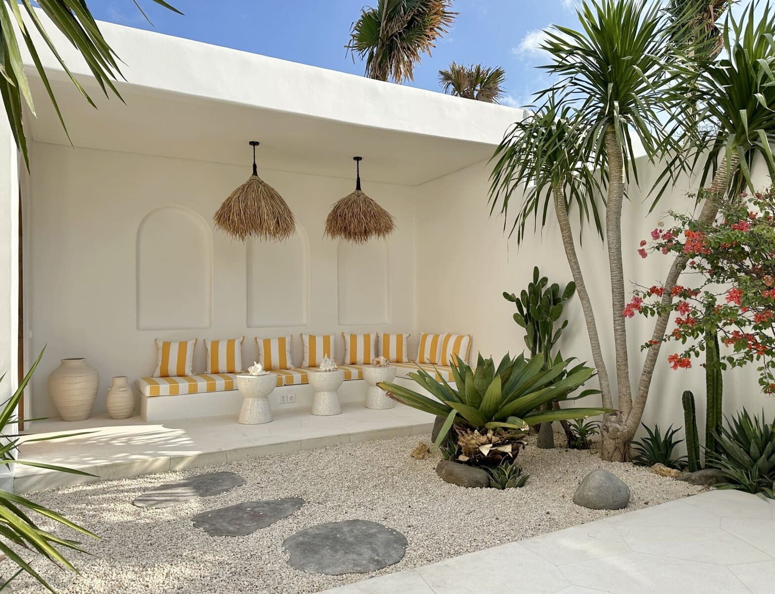 Elegant Bali villa featuring minimalist design, outdoor lounge, and tropical plants.