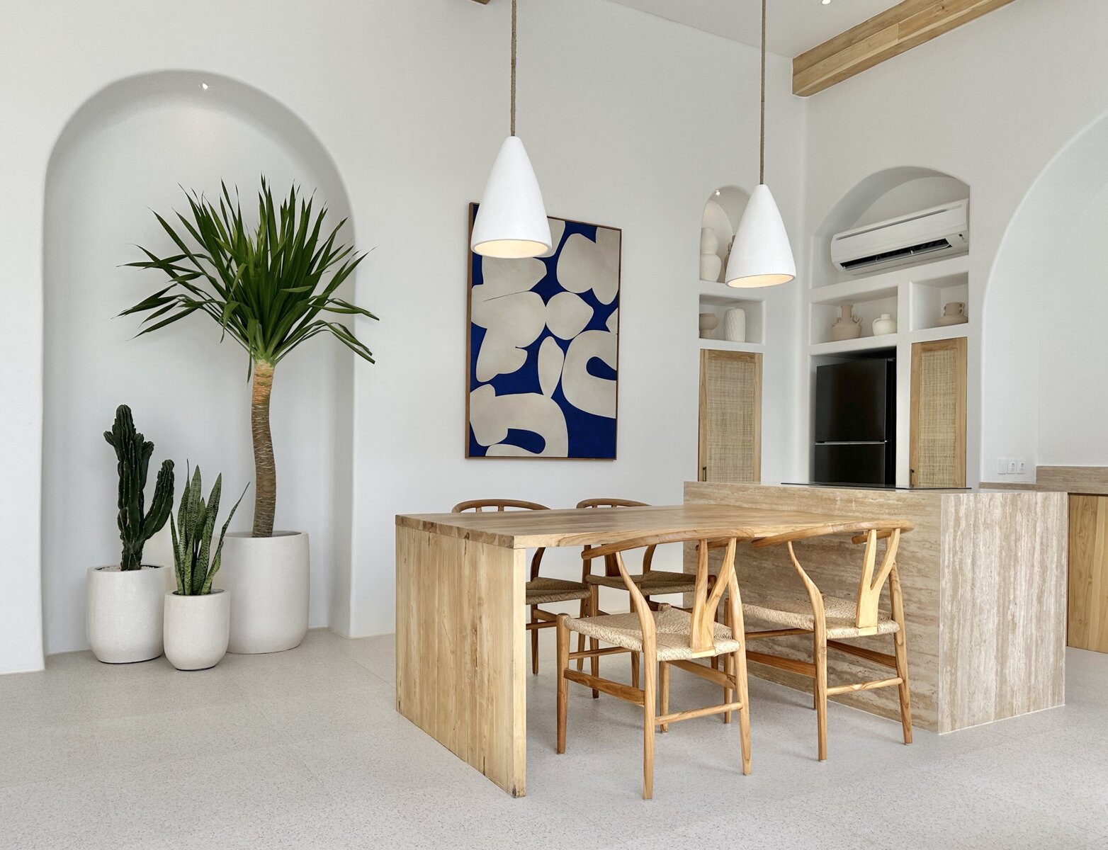 Bright, modern dining area featuring natural wood furniture and lush indoor plants.