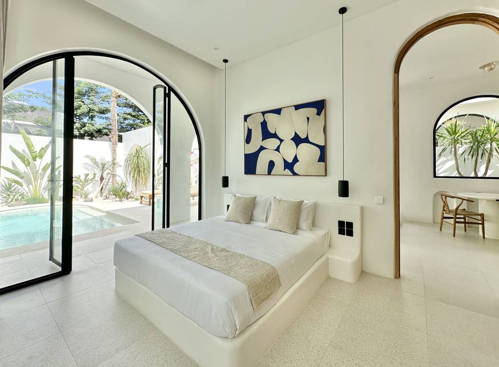 Modern bedroom with pool view, natural light, minimal decor. Perfect for Bali tropical retreats.