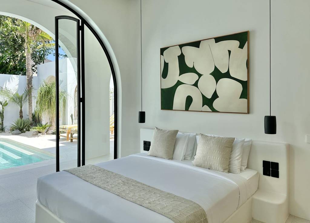 Elegant bedroom with pool view, stylish art accent, and tropical Bali vibes.