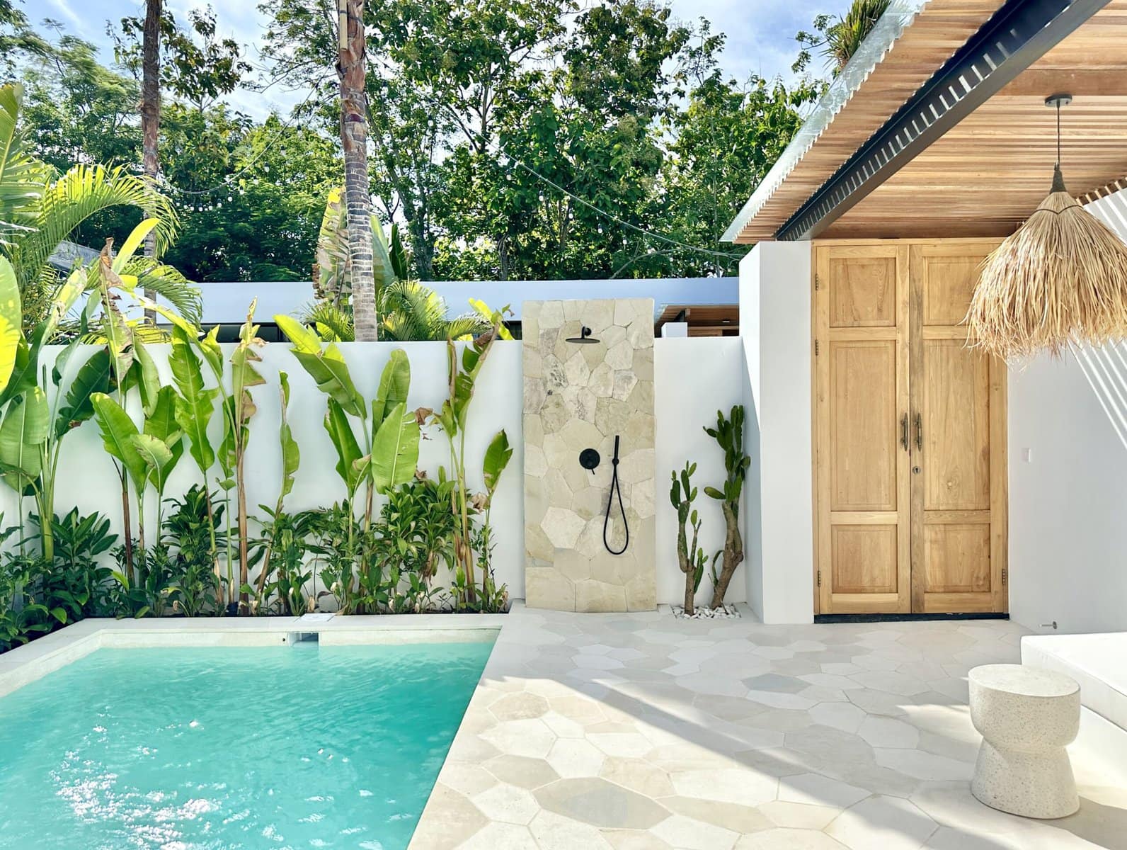 Beautiful modern outdoor area with a pool, lush greenery, and stylish minimal design.