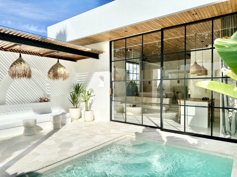 Bright, airy indoor-outdoor Bali villa featuring glass walls and stylish decor for a relaxing stay.