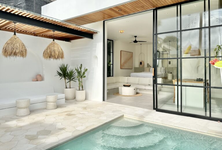 Modern tropical open-plan living space with pool view.