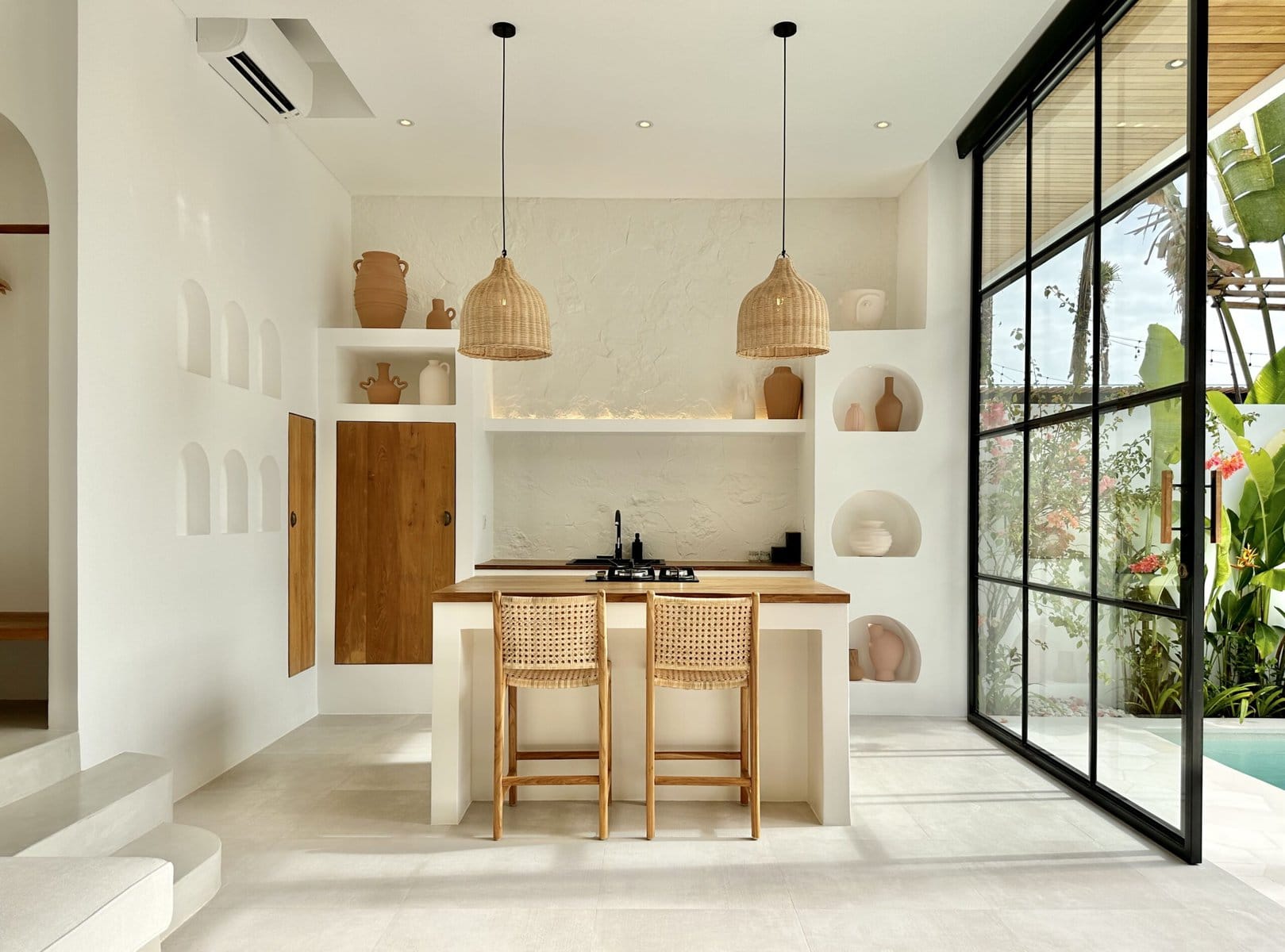 Bright, modern minimalist Bali interior with natural wood accents and floor-to-ceiling glass.