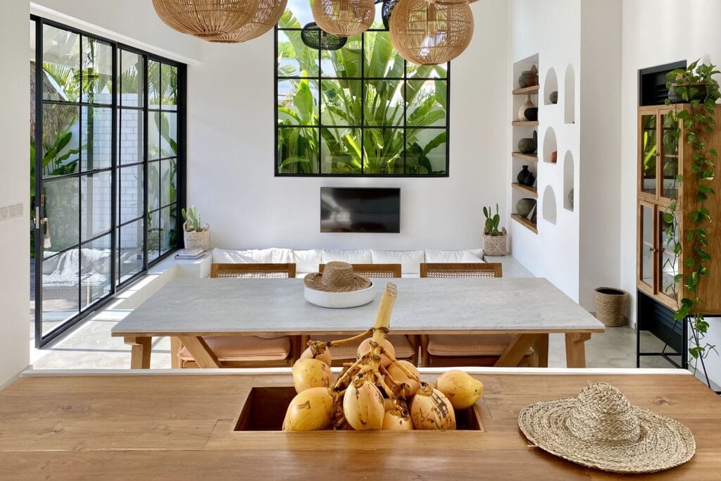 Bright modern living space with tropical decor and large windows.