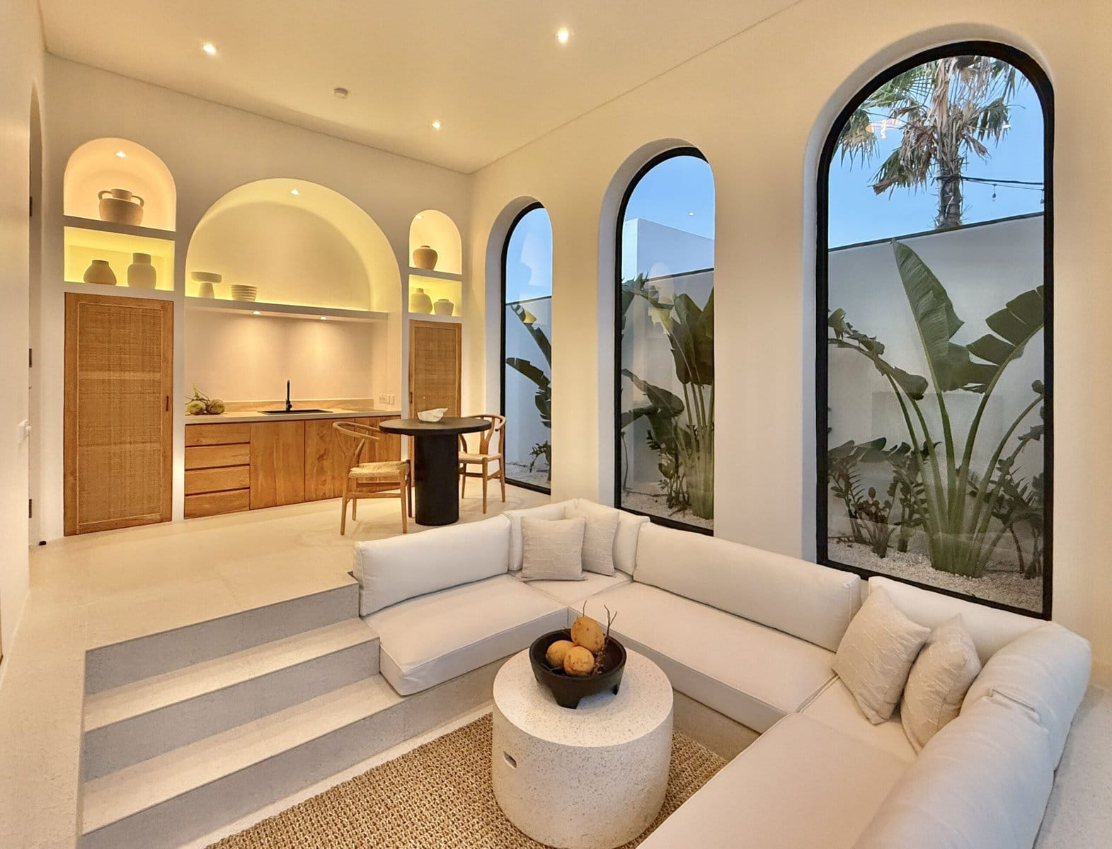 Bright minimalist interior with high-end decor and large arched windows. Perfect for a tropical-modern Uluwatu getaway.