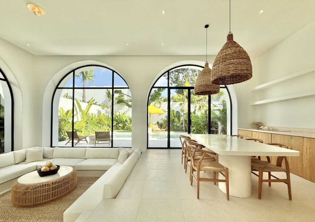 Bright, airy interior featuring large arched windows and tropical design elements.