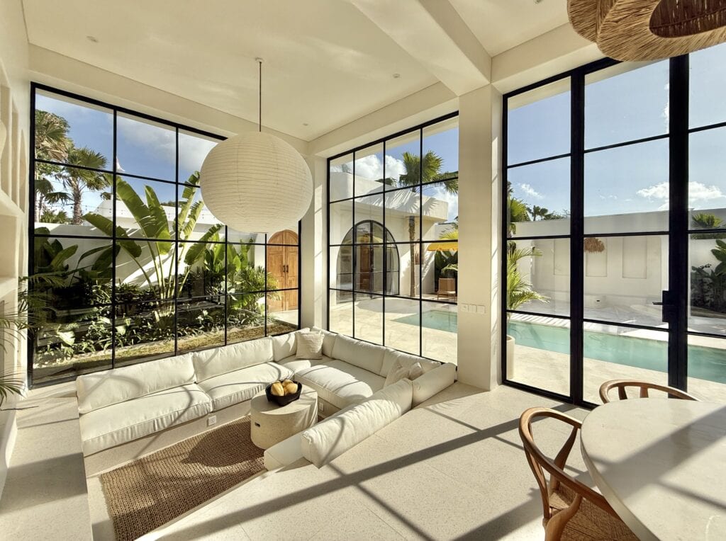 Bright, spacious interiors with large windows, lush outdoor garden, and private pool.