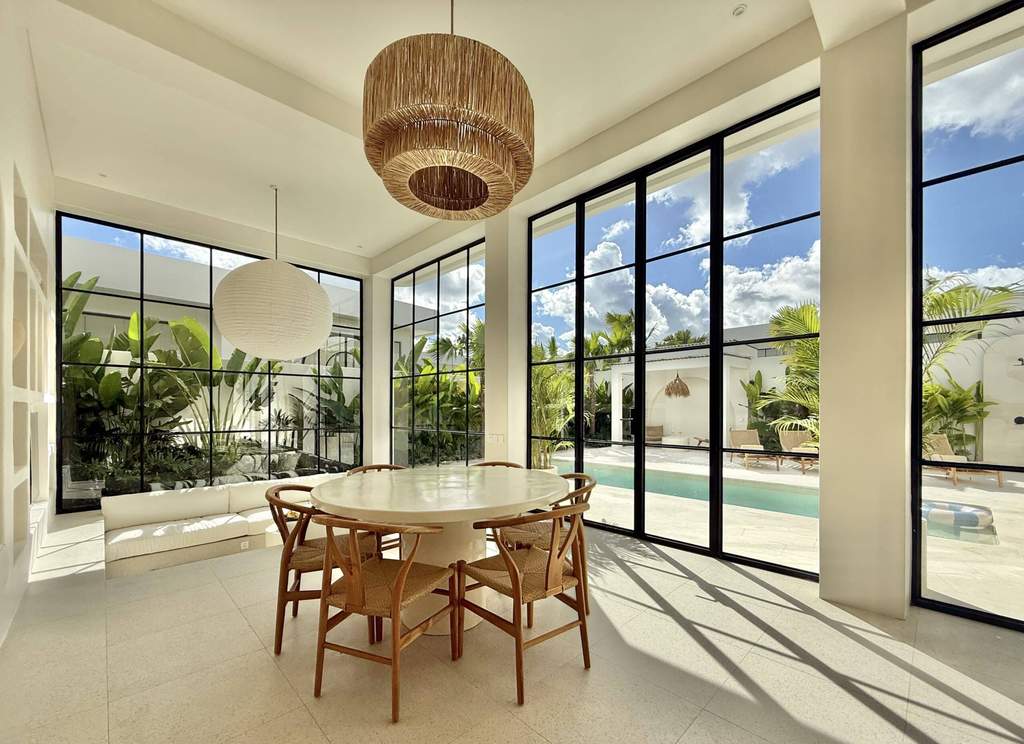 Bright, modern living space with large windows and tropical decor in Uluwatu.