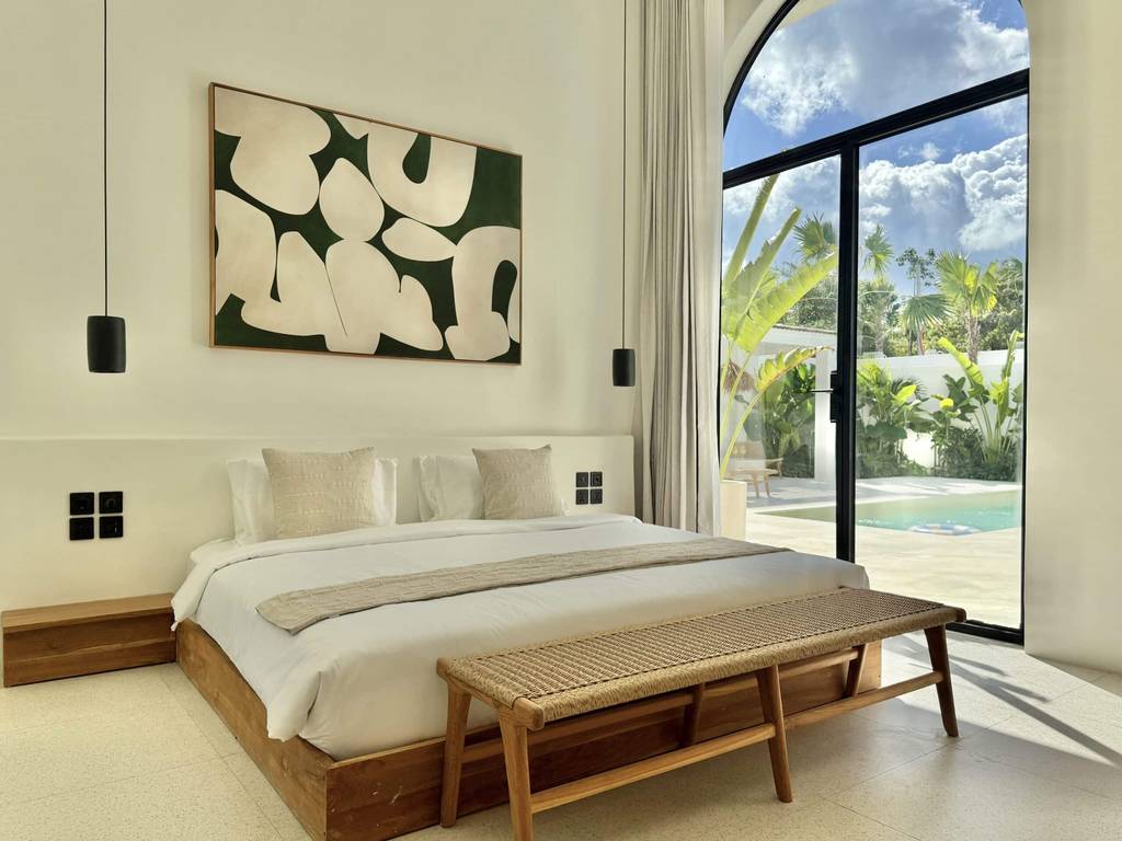Stylish tropical-modern bedroom with pool view.