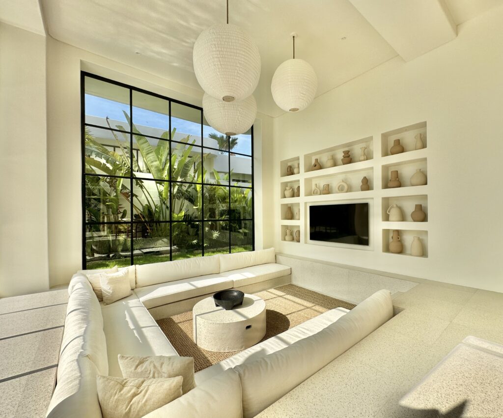 Bright modern living room with minimalist decor and large windows.