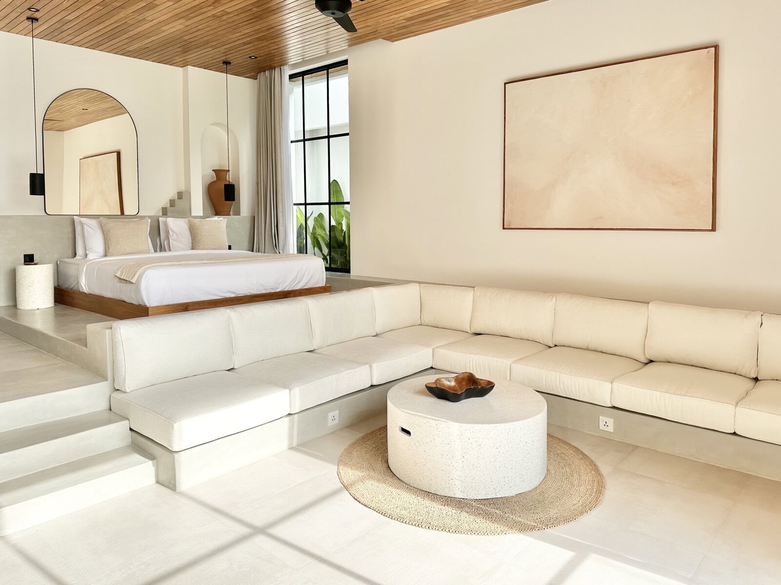 Elegant bedroom and spacious living area with neutral tones, natural light, and stylish decor in a Bali villa.
