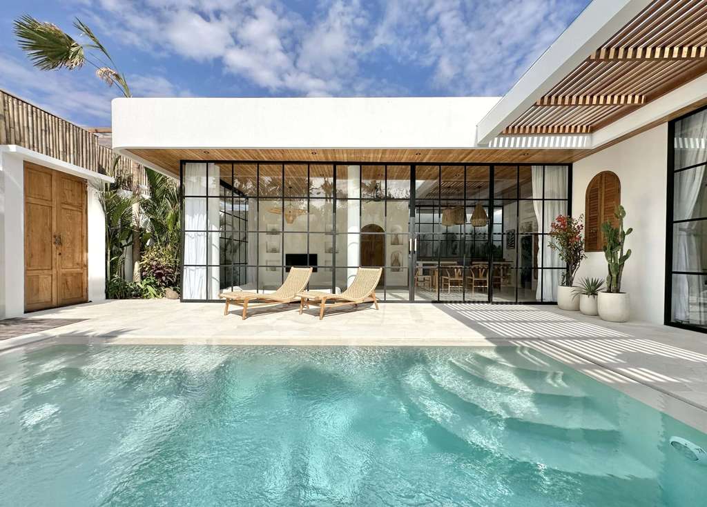 Bright, inviting contemporary villa with pool, outdoor lounge, and lush garden views.