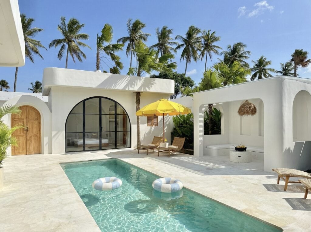 A stunning white-washed villa in Uluwatu with a pool, tropical decor, and airy interiors for a luxury vacation.