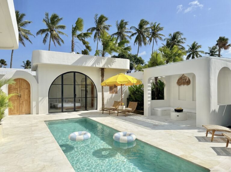 A stunning white-washed villa in Uluwatu with a pool, tropical decor, and airy interiors for a luxury vacation.