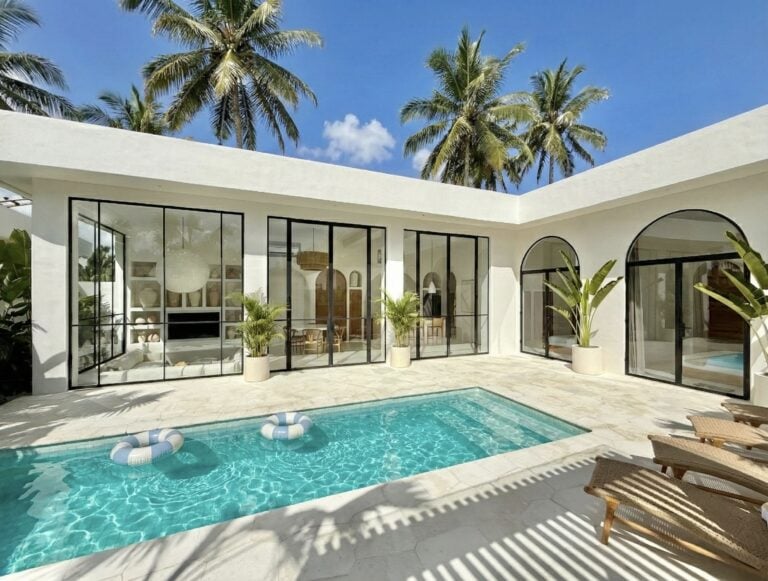 High-end modern villa featuring a private pool, lush palms, and stylish interiors, ideal for a luxurious Bali vacation in Uluwatu.