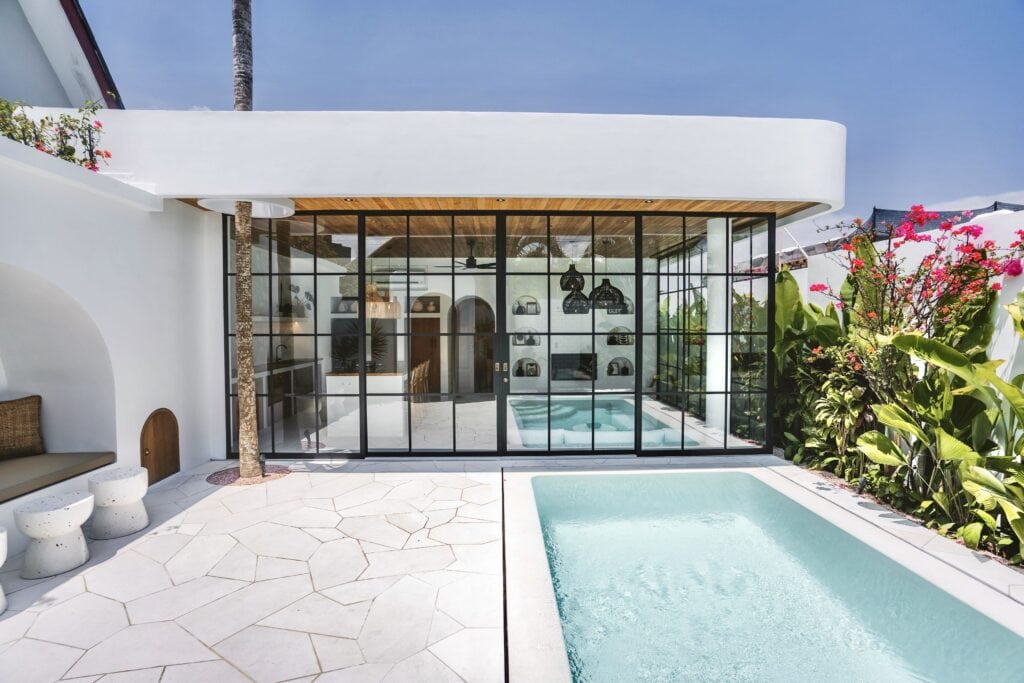 Elegant one-bedroom villa featuring a sunlit indoor pool, sleek architecture, and lush garden views in Canggu, Bali.