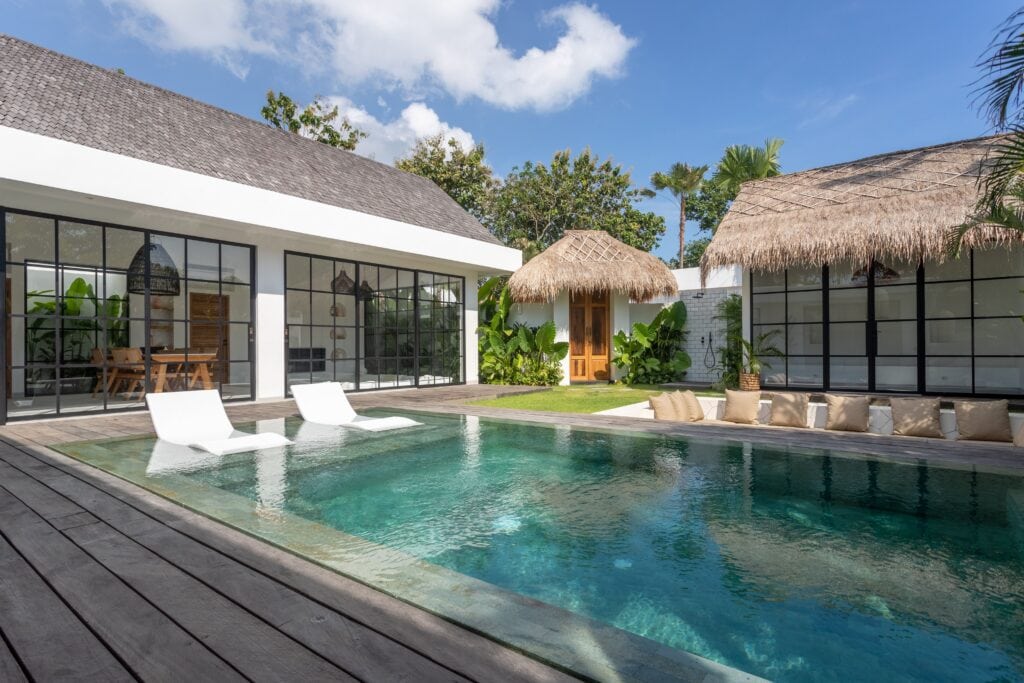 Stylish beachfront villa showcasing a serene private pool, minimalist decor, and lush greenery in Uluwatu. Ideal for luxury travelers.