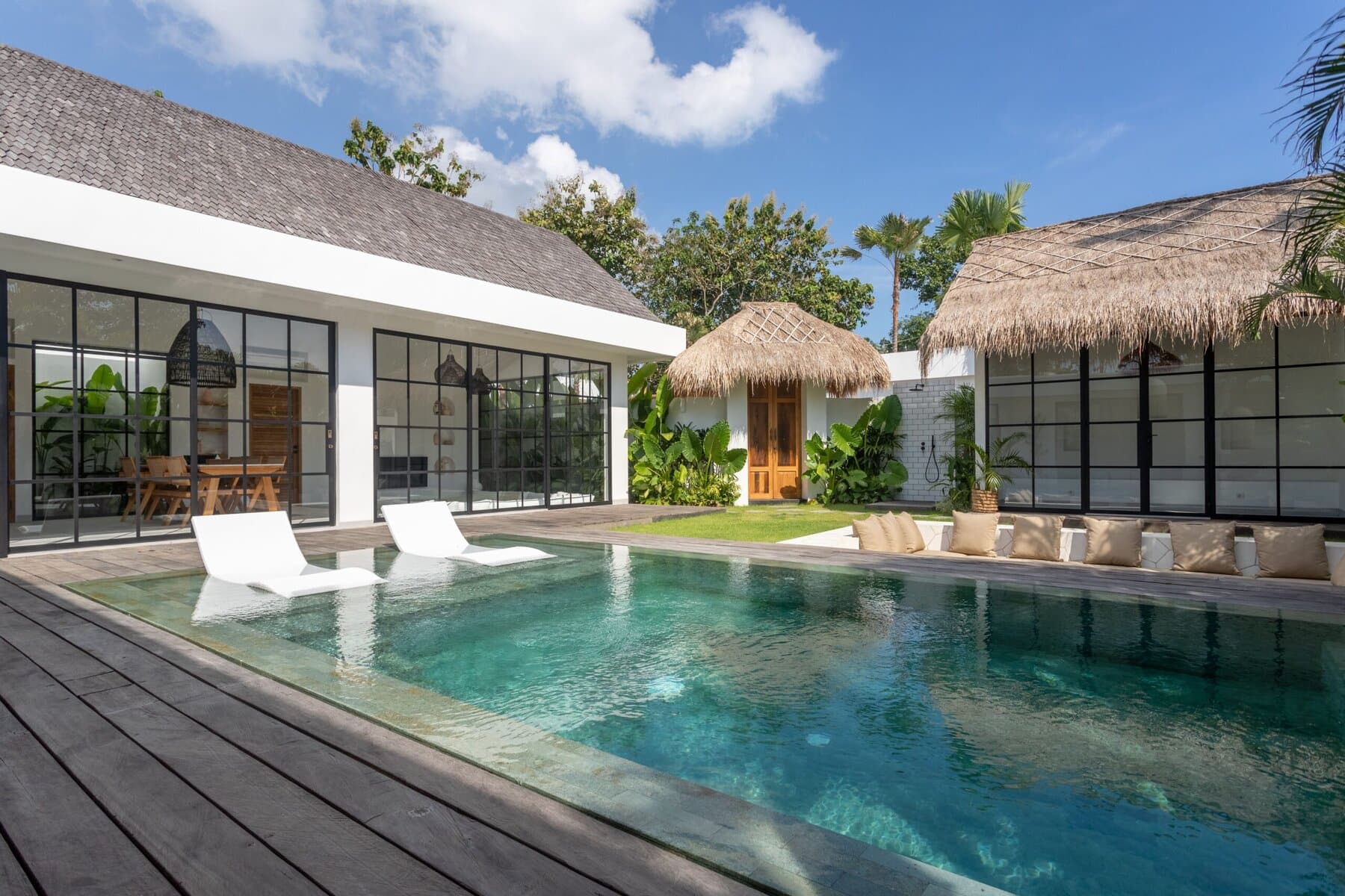 Stylish beachfront villa showcasing a serene private pool, minimalist decor, and lush greenery in Uluwatu. Ideal for luxury travelers.