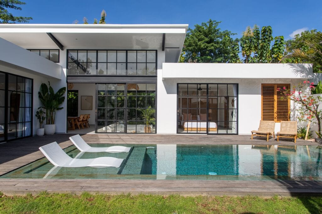 Modern Bali villa with pool and tropical garden views.