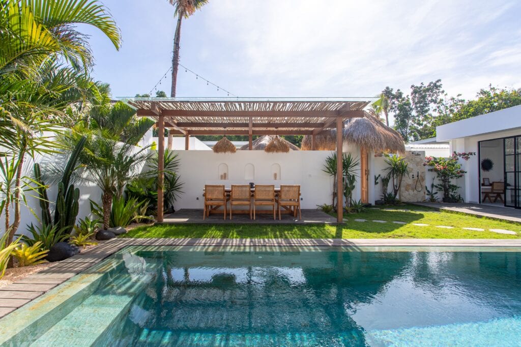 Poolside relaxation in a modern Bali villa with tropical decor.