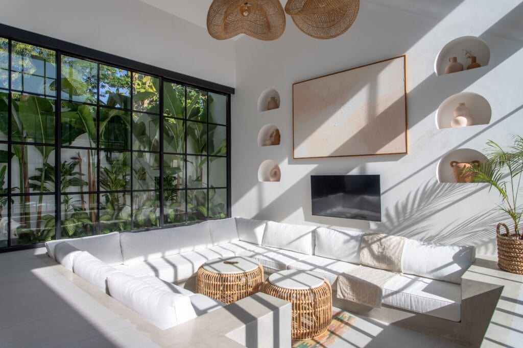 Luxurious Bali villa interior featuring a sleek, modern living space with large windows, natural light, and minimalist design.
