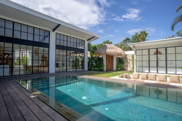High-end minimalist villa featuring a private pool, sleek glass walls, and tropical decor in Uluwatu.