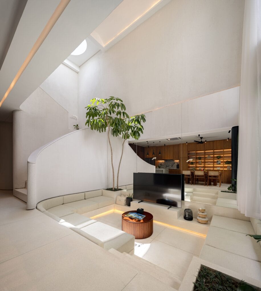 Stylish minimalistic living space with high ceilings, natural light, and lush greenery.