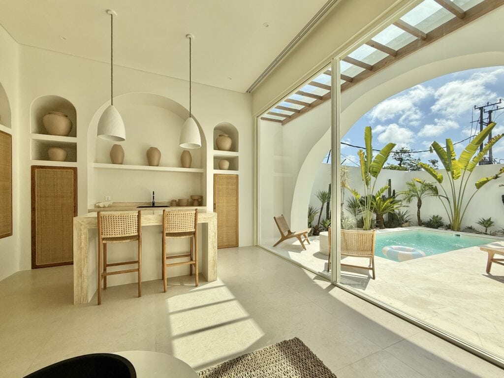 Elegant minimalist interior with outdoor pool and lush garden view in Bali.