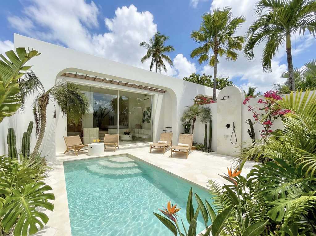 Modern tropical villa with private pool in Bingin, Bali, surrounded by lush greenery and vibrant flowers.