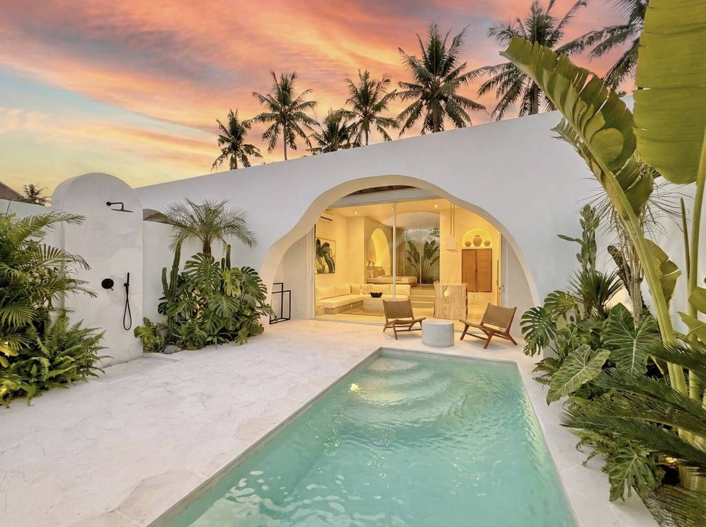Modern tropical-style private pool and outdoor lounge area at sunset.