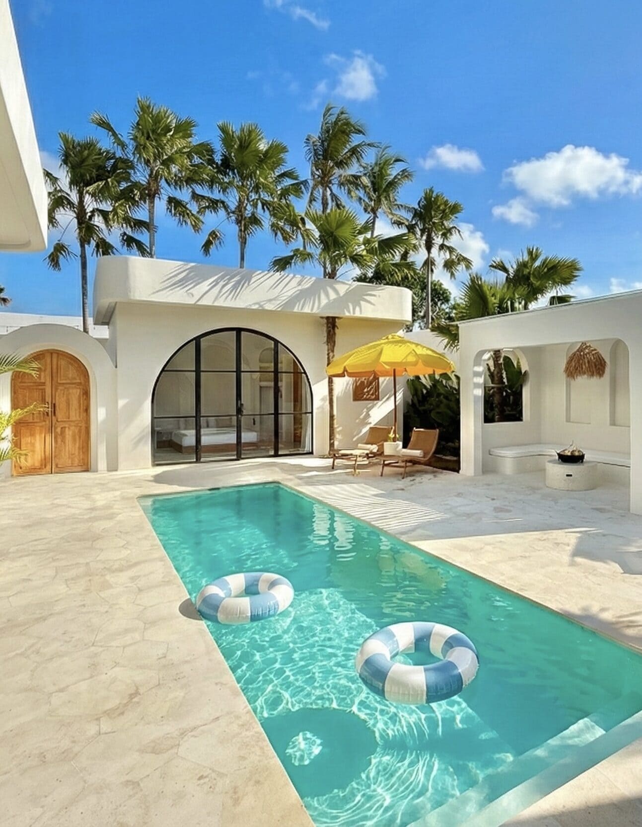 Luxurious Bali vacation rental with pristine pool, lush palm trees, and sleek minimalist design.